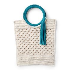 a crocheted bag with a tassell hanging from the handle, on a white background