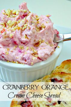 cranberry orange cream cheese spread in a white bowl next to a biscuit