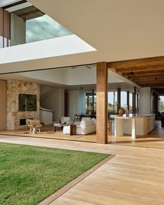 an open living room and dining area with wood flooring, large windows, and sliding glass doors