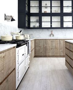 a kitchen with wooden cabinets and marble counter tops, along with an oven in the center