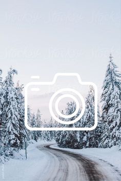 a camera is shown in the middle of a snowy road with trees on both sides