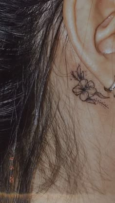 a close up of a person's ear with flowers on the back of their ear