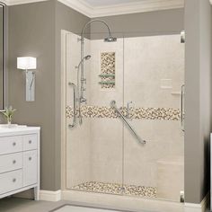 a bathroom with a walk in shower next to a white dresser