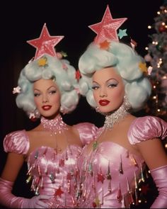 two women dressed in pink wigs and stars on their heads