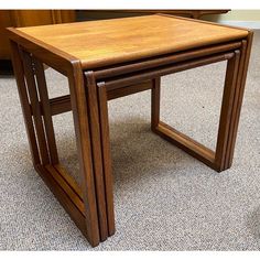 two wooden tables sitting on top of a carpeted floor