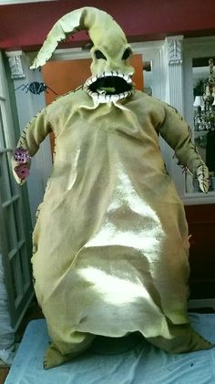 a large stuffed animal sitting on top of a blue sheet covered table next to a doorway