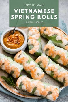 several shrimp rolls on a plate with dipping sauce