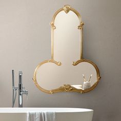 a bath tub sitting next to a white sink under a large mirror on the wall