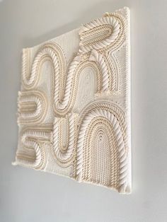 a white wall hanging on the side of a building with an intricately designed design