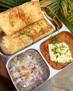 a person holding a metal tray filled with different types of food on top of it