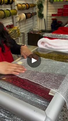 a woman is working on some fabric