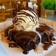 a piece of cake with ice cream and chocolate drizzled on the top