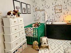 a baby's room with a crib, dresser and stuffed animals on the floor