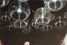 a woman standing in front of shiny disco balls