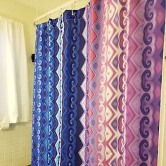 a bathroom with a shower curtain, toilet and sink