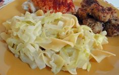 a yellow plate topped with meat, pasta and coleslaw on top of a table