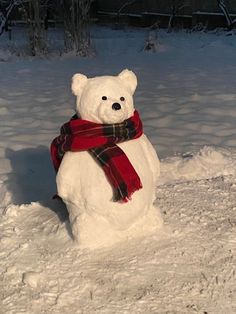 a snowman made to look like a teddy bear with a scarf around its neck