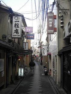 an alley way with buildings and signs on both sides