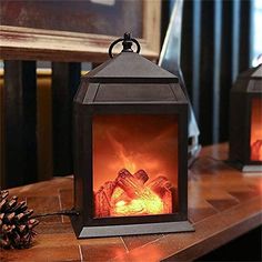 an open fire place sitting on top of a wooden table next to a pine cone