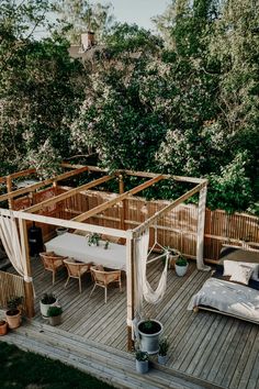 a wooden deck with an outdoor bed and canopy