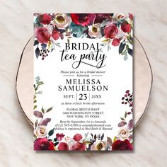 an elegant floral bridal tea party card on a marble table with white and red flowers