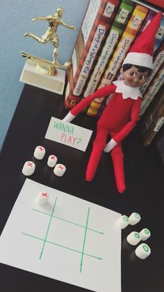 an elf is playing tic - tac on the table next to some books