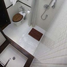 a bathroom with a toilet, sink and shower in it's stall area is seen from above