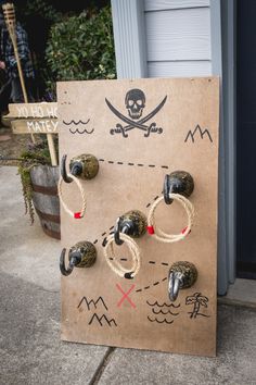 a wooden board with pirate symbols on it and ropes attached to the back of it