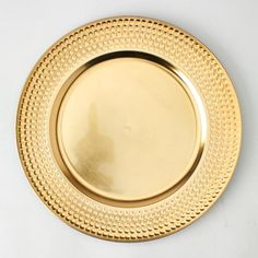 an empty gold plate on a white surface