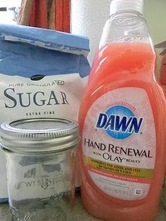 a bottle of dawn liquid sitting on top of a counter next to a bag of sugar