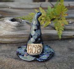 a figurine sitting on top of a piece of wood