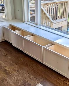 a window sill with drawers in front of it on a wooden floor next to a window