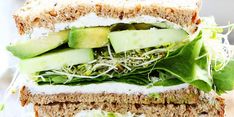 a sandwich with cucumber, lettuce and cheese