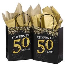 two black and gold gift bags with cheers to 50 years printed on the front each