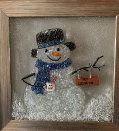 a snowman with a name tag in a frame