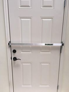 a white door with a black handle on the front and side bars attached to it