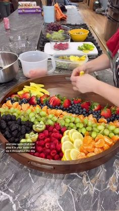 a woman standing in front of a tray filled with fruit