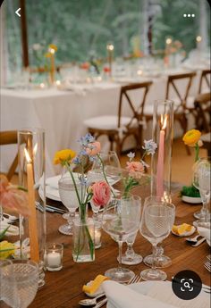 the table is set with flowers, candles and place settings for an elegant dinner party