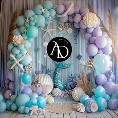 an ocean themed backdrop with balloons and seashells