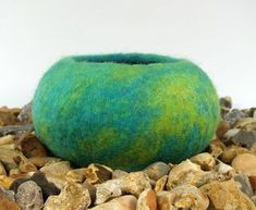 a green ball sitting on top of some rocks