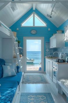 a blue and white living room with a ladder leading up to the door that leads to an ocean view