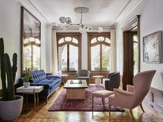 a living room with couches, chairs and a cactus in the middle of the room