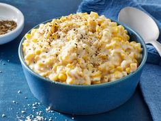 a blue bowl filled with macaroni and cheese on top of a blue table