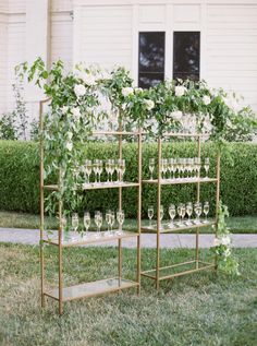 a set of wine glasses sitting on top of a shelf in front of a house