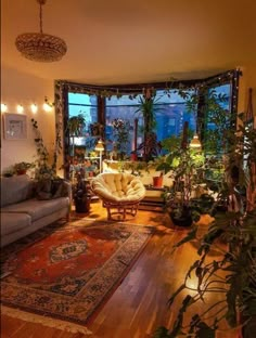 a living room filled with furniture and lots of plants on top of a hard wood floor