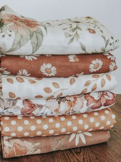 a stack of cloths sitting on top of a wooden table next to each other