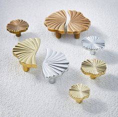 four different types of decorative knobs on a white carpeted surface, one with gold and silver accents