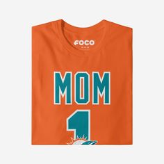 She’s not just your mom, she’s the best one around! A mom as amazing as yours deserves a shirt that shows off her favorite team. Make sure everyone knows how great of a mom and fan she is with this Miami Dolphins #1 Mom T-Shirt. This top features a design that showcases your all-important team colors and a bold team logo display across the chest, meaning this t-shirt will prove your unmatched dedication to the Miami Dolphins when you’re at the game or watching at home with your #1 family. In oth Sporty Graphic Print T-shirt For Mother's Day, Sporty Crew Neck T-shirt For Mother's Day, Mother's Day Sports T-shirt With Letter Print, Sporty Short Sleeve Tops For Mother's Day, One Piece Pajamas, Team T Shirts, Team Shirts, Miami Dolphins, Your Mom