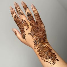 a woman's hand with henna tattoos on it