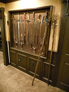 a bunch of knives hanging on a wall in a room with carpeted flooring